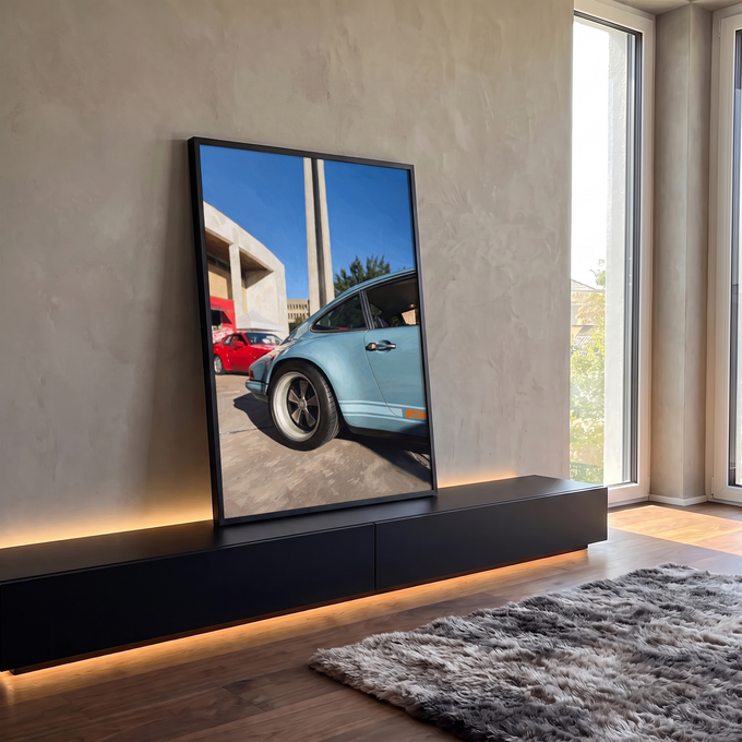 Porsche 911 clássico azul claro com rodas esportivas, carro vermelho e obelisco ao fundo, quadro decorativo