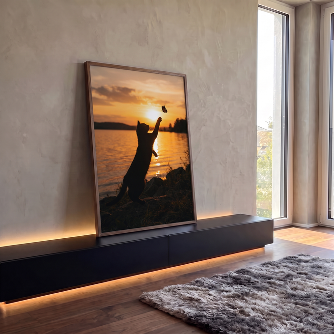 Silhueta de gato em pé tentando pegar borboleta no pôr do sol laranja sobre lago, quadro decorativo
