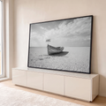 Barco de madeira antigo em terra seca e rachada com placa HOME sob céu nublado, em preto e branco, quadro decorativo