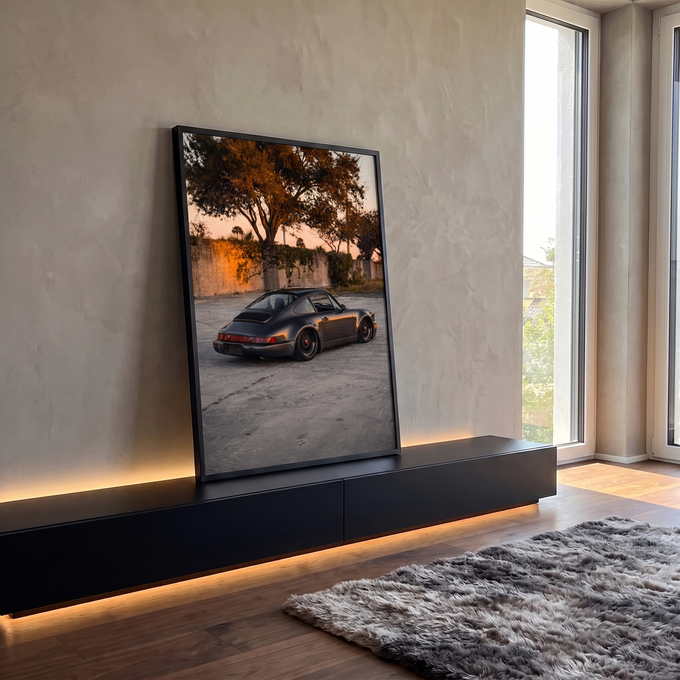 Porsche 911 cinza grafite rebaixado com rodas bronze ao pôr do sol diante de muro, quadro decorativo
