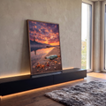 Praia ao pôr do sol com farol, barcos, garrafa e estrelas-do-mar na areia, quadro decorativo