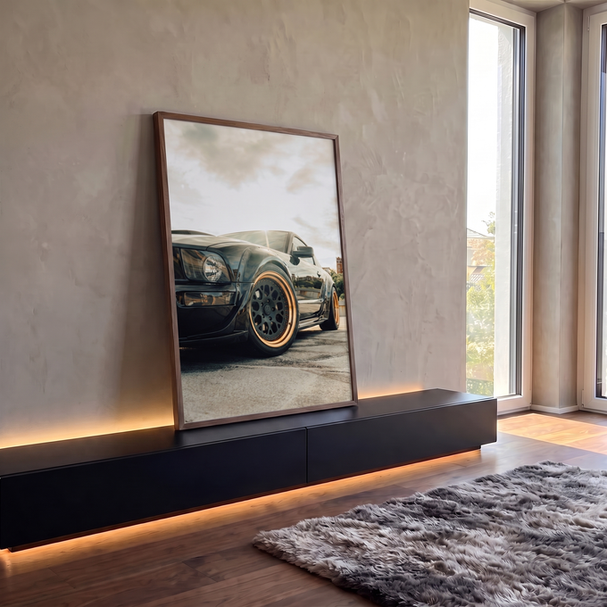 Carro esportivo preto widebody com rodas bronze em ângulo baixo sob céu claro, quadro decorativo