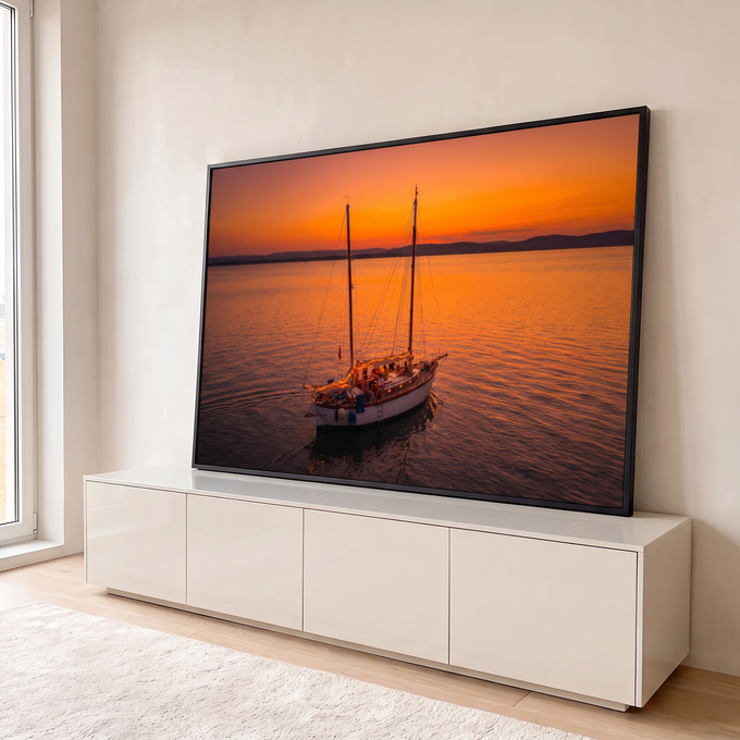 Quadro Decorativo Grande Veleiro Iluminado para Sala Laranja | quadros decorativos para sala | veleiro de dois mastros iluminado com luzes, ancorado em mar calmo ao pôr do sol laranja | em Quadros para Sala | Porao dos Quadros