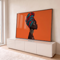 Mulher negra de perfil com turbante azul e vermelho e brinco dourado, fundo laranja, quadro decorativo
