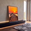 Quadro Decorativo Grande Píer de Madeira para Sala Laranja | quadros decorativos para sala | deck de madeira levando a quiosque com pôr do sol laranja refletido na água | em Quadros para Sala | Porao dos Quadros