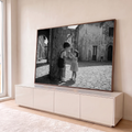 Foto preto e branco de menino e menina dividindo sorvete em rua de vila italiana, quadro decorativo