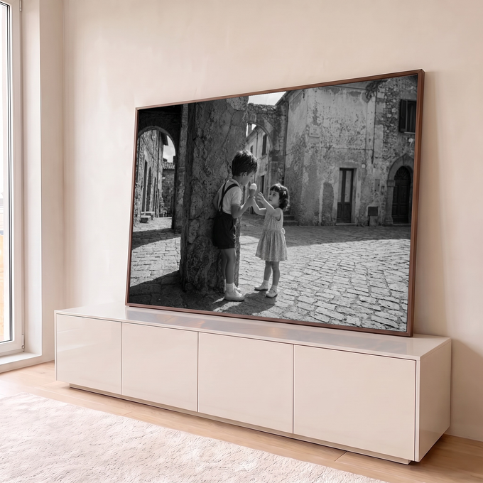 Foto preto e branco de menino e menina dividindo sorvete em rua de vila italiana, quadro decorativo