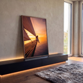 Mulher sentada na proa de veleiro sobre o mar ao pôr do sol em tons laranja, quadro decorativo