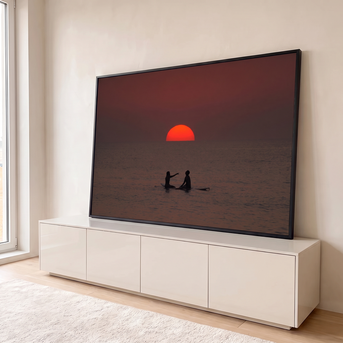 Quadro Decorativo Grande Casal Surfistas para Sala Vermelho | quadros decorativos para sala | silhuetas de duas pessoas em prancha de surfe diante de pôr do sol vermelho intenso | em Quadros para Sala | Porao dos Quadros