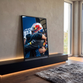 Quadro Decorativo Grande Abraço para Sala Azul | quadros decorativos para sala | dois homens se abraçando, um com capacete de corrida colorido e outro de macacão azul | em Quadros para Sala | Porao dos Quadros