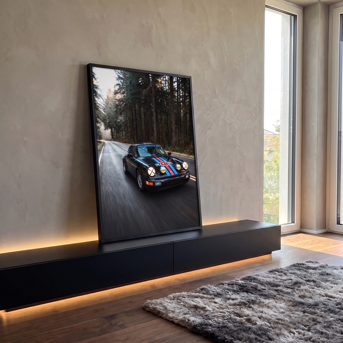 Porsche 911 preto com faixas Martini em velocidade numa estrada cercada por pinheiros, quadro decorativo