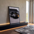 Quadro Decorativo Grande Esportivo Fosco para Sala Preto | quadros decorativos para sala | vista traseira de carro esportivo preto fosco com faixas amarelas em garagem industrial | em Quadros para Sala | Porao dos Quadros