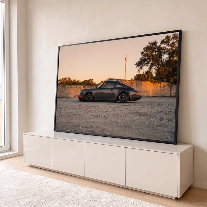 Porsche 911 clássico cinza rebaixado de perfil ao pôr do sol, sobre cascalho e muro, quadro decorativo