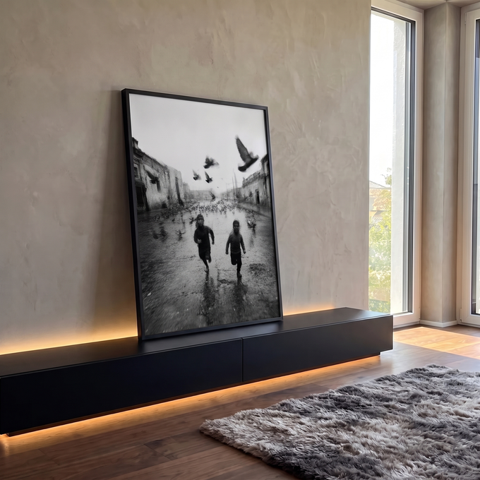 Fotografia preto e branco de dois meninos correndo entre pombos em rua antiga molhada, quadro decorativo