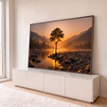 Quadro Decorativo Grande Árvore Solitária Rio para Sala | quadros decorativos para sala | árvore solitária sobre pedras à beira de rio com sol poente entre galhos e montanhas ao fundo | em Quadros para Sala | Porao dos Quadros