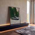 Porsche 911 cinza estacionado em pátio de pedra diante de muro de tijolos coberto de hera, quadro decorativo