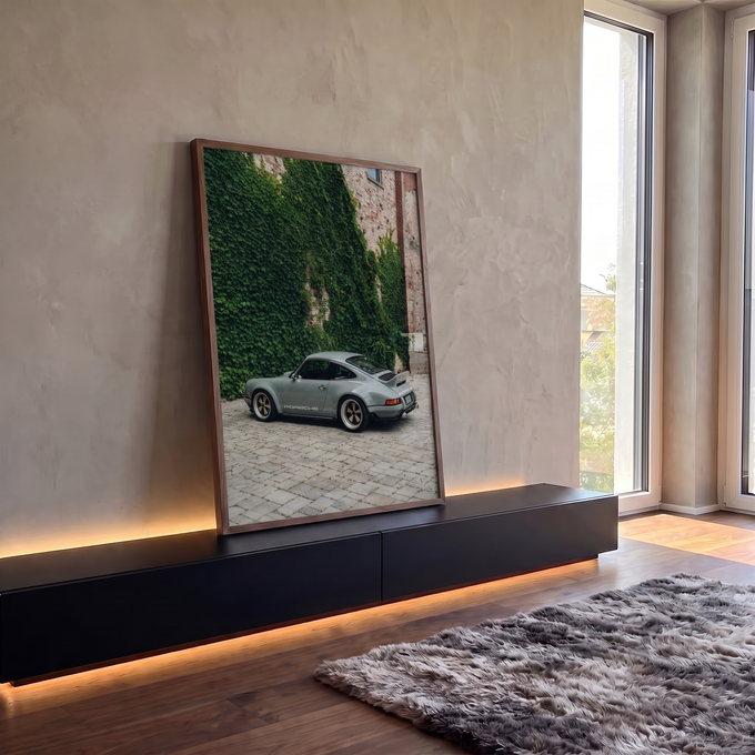 Porsche 911 cinza estacionado em pátio de pedra diante de muro de tijolos coberto de hera, quadro decorativo