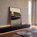 Porsche 911 preto rebaixado com rodas raiadas e trem de carga borrado ao pôr do sol, quadro decorativo