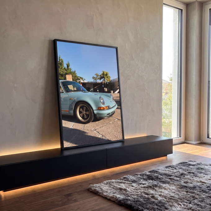 Porsche 911 vintage azul-claro com faixa laranja e rodas clássicas sob céu azul, quadro decorativo