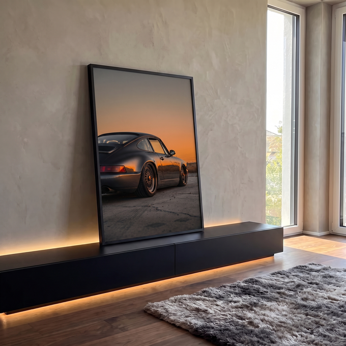 Porsche 911 cinza rebaixado com rodas douradas sob céu laranja de pôr do sol, quadro decorativo
