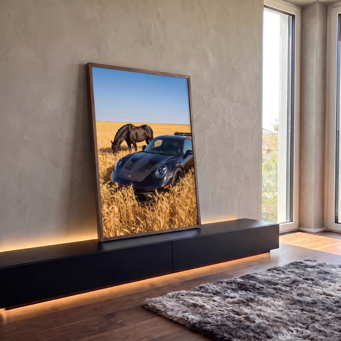 Porsche preto em campo de trigo dourado, cavalo preto pastando e céu azul, quadro decorativo