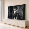 Fotografia preto e branco de menino de cabelos cacheados abraçando um cordeiro branco, quadro decorativo
