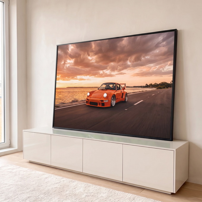 Porsche clássico laranja com aerofólio em estrada à beira-mar sob céu de pôr do sol, quadro decorativo
