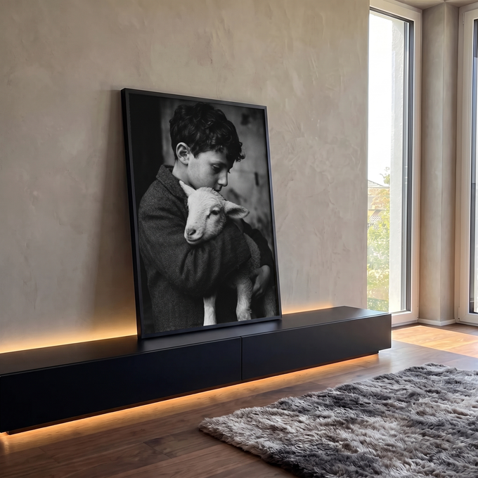 Fotografia preto e branco de menino de cabelo cacheado abraçando um cordeiro, quadro decorativo