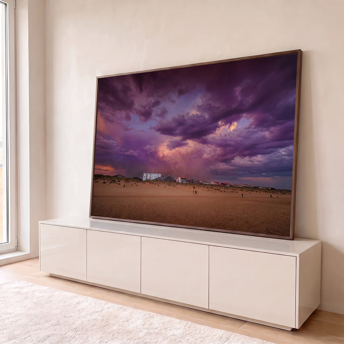 Quadro Decorativo Grande Céu de Tempestade para Sala Roxo | quadros decorativos para sala | céu roxo dramático de tempestade sobre praia com casas e pessoas distantes | em Quadros para Sala | Porao dos Quadros