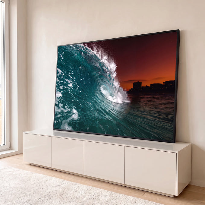Onda do mar formando tubo azul-turquesa com céu laranja e prédios na orla ao entardecer, quadro decorativo