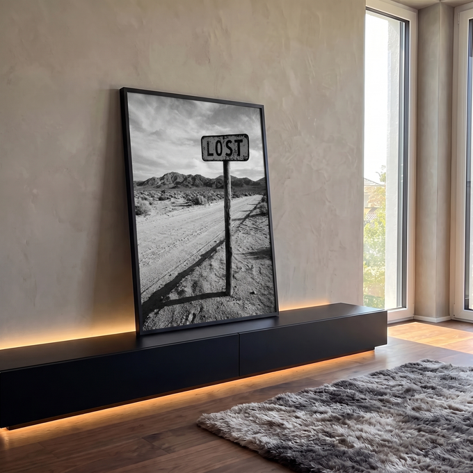 Placa Lost em poste de madeira numa estrada de terra no deserto com montanhas, foto P&B, quadro decorativo
