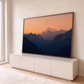 Quadro Decorativo Grande Cordilheira em Camadas para Sala | quadros decorativos para sala | cordilheira em camadas azuis sob céu laranja ao entardecer com pico nevado ao fundo | em Quadros para Sala | Porao dos Quadros