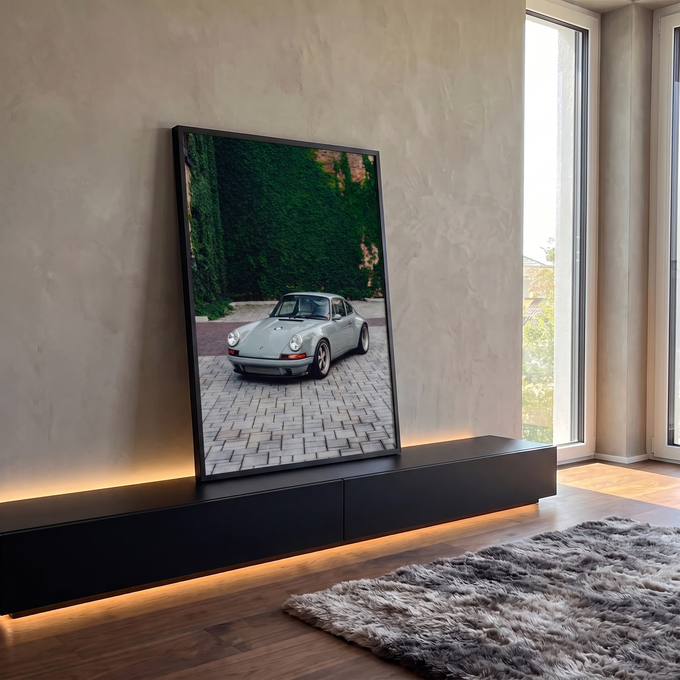 Porsche 911 clássico cinza estacionado em piso de pedras diante de parede coberta de hera, quadro decorativo