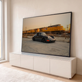 Porsche 911 preto rebaixado diante de trem de carga amarelo borrado sob céu de entardecer, quadro decorativo