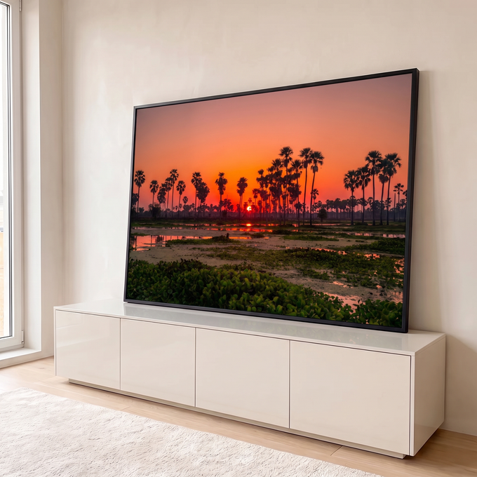 Pôr do sol laranja entre palmeiras em silhueta refletido em lagoa com plantas aquáticas, quadro decorativo