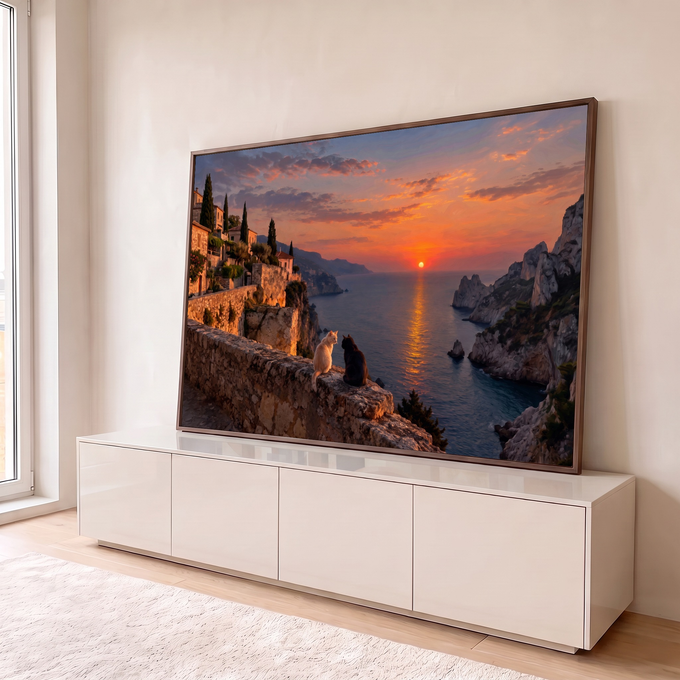 Dois gatos num muro de pedra olhando o pôr do sol laranja sobre o mar, penhascos e vilarejo, quadro decorativo