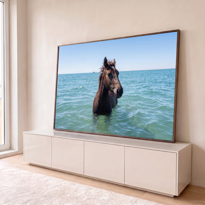 Cavalo marrom com a crina ao vento dentro do mar turquesa e veleiro no horizonte, quadro decorativo