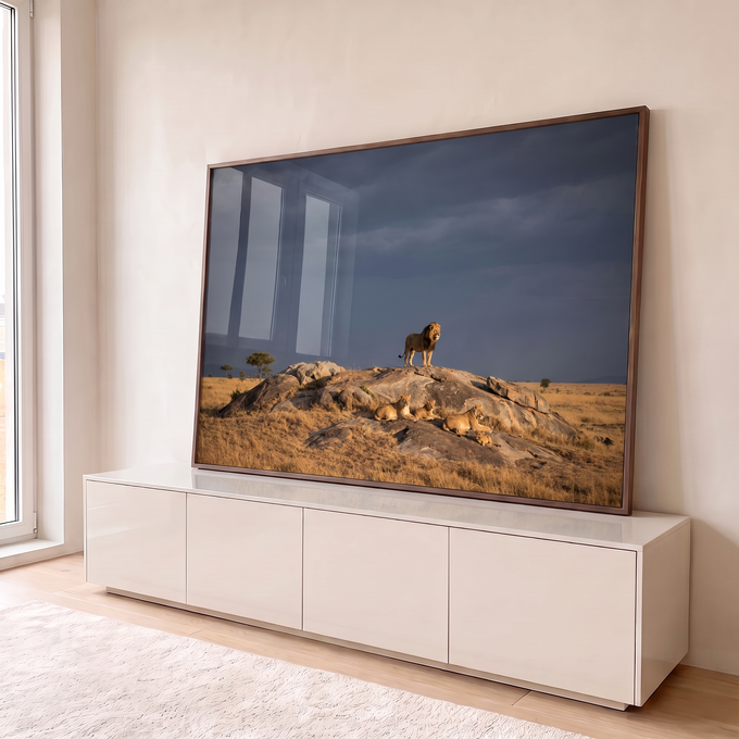 Quadro Decorativo Grande Leão em Pé para Sala Cinza | quadros decorativos para sala | leão em pé sobre rocha com família de leões descansando sob céu tempestuoso | em Quadros para Sala | Porao dos Quadros