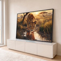 Filhote de leão bebendo água em poça com reflexo, savana dourada e pôr do sol ao fundo, quadro decorativo