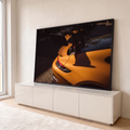 Traseira de carro esportivo laranja com aerofólio preto e lanterna em luz de fim de tarde, quadro decorativo