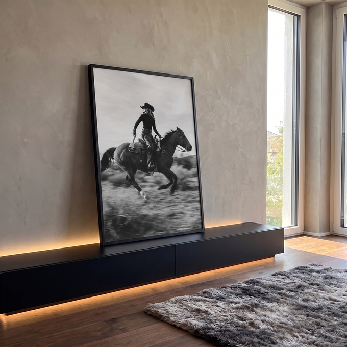 Cowgirl de chapéu galopando cavalo escuro no campo, foto preto e branco com movimento, quadro decorativo