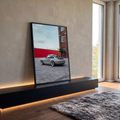 Porsche 911 retrô cinza estacionado em pátio com muro vermelho e prédio de tijolos, quadro decorativo