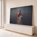 Mulher de vestido vermelho montada em cavalo branco sobre píer de pedra em lago escuro, quadro decorativo