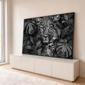 Leopardo de olhar intenso entre folhas de monstera em preto e branco, quadro decorativo