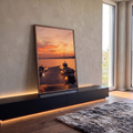 Pôr do sol laranja sobre o mar com cais de madeira, lanternas acesas e barcos, quadro decorativo
