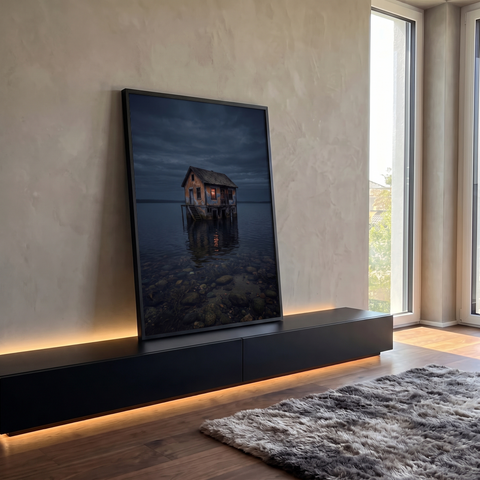 Casa de madeira sobre palafitas em lago escuro ao anoitecer com janela acesa e reflexo, quadro decorativo