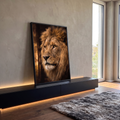 Close de leão com juba farta e olhos âmbar olhando de lado sobre fundo escuro, quadro decorativo