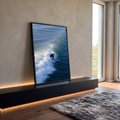 Surfista de roupa preta em prancha azul sobre onda do mar com espuma branca e movimento, quadro decorativo