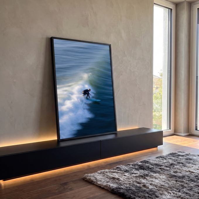 Surfista de roupa preta em prancha azul sobre onda do mar com espuma branca e movimento, quadro decorativo