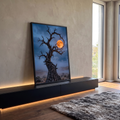 Árvore seca retorcida com galhos em espiral envolvendo lua cheia laranja no deserto azul, quadro decorativo